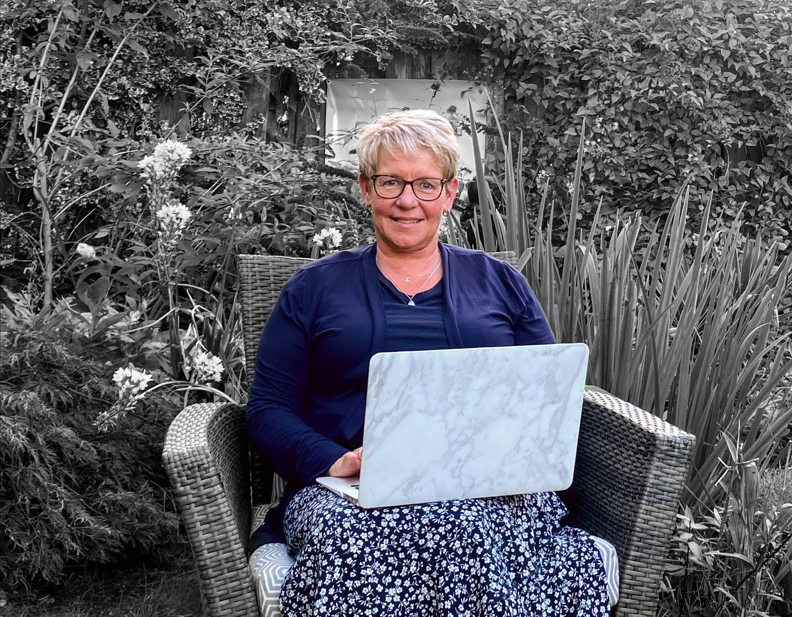 Coach Annelies, werkend aan de computer buiten.